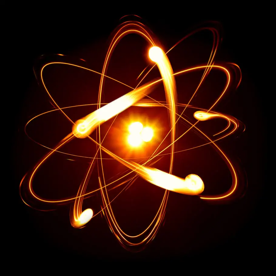 Um átomo desenhado com seu núcleo incandescente e elétrons girando em diferentes planos da eletrosfera.